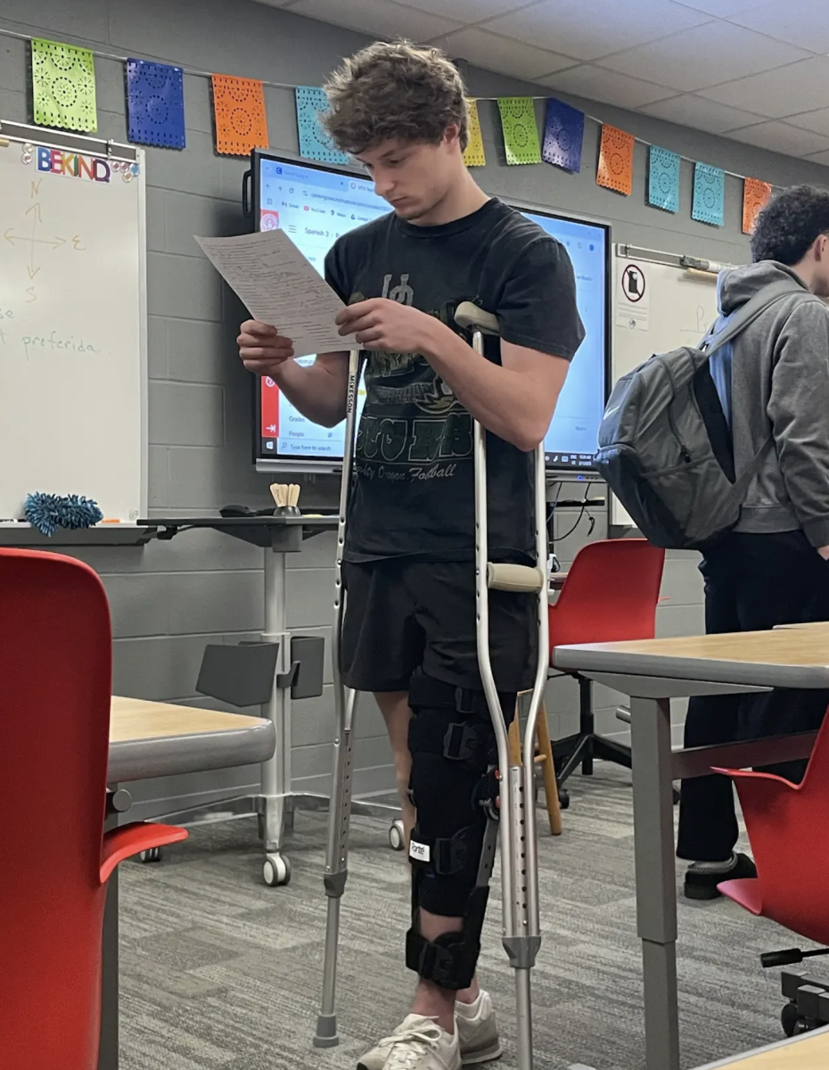 Chase Epperson, Junior, reviews his Spanish quiz perched between his crutches, following his knee surgery this past Monday, getting around school has been difficult for him . “It’s very hard and tiring getting around, Chase states, “Classes are very far, and I’m still learning how to get around .”